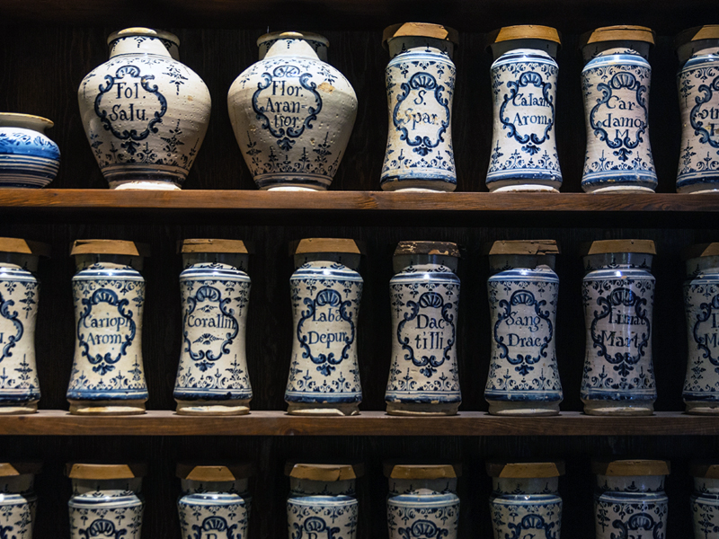 Wooden shelves lined with blue-and-white ceramic apothecary jars.